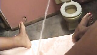 ebony babe sprays the toilet with piss from across the room