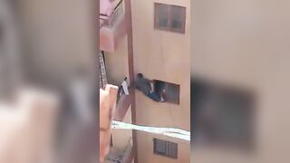 Crazy woman tries to force her son to climb into their apartment from the window to get the keys