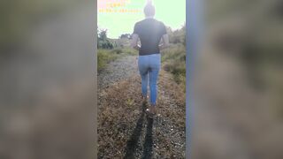 Wetting her jeans while walking on the side of the road