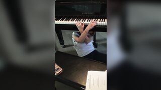 Legendary voice actor Tara Strong attempts to play her own piano while sitting under it